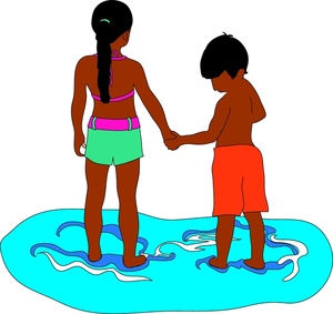 hispanic children brother and sister holding hands at the beach